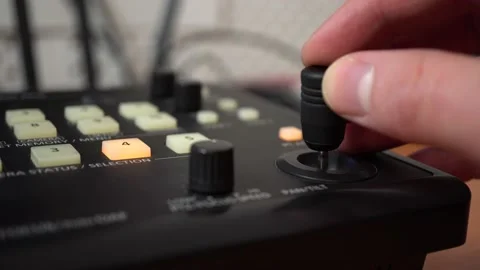 Control panel for remote cameras. The man moves the joystick and presses the Stock Footage 232056233