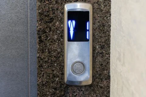 The control panel of a steel elevator displays illuminated numbers, showing.. Stockfoto's