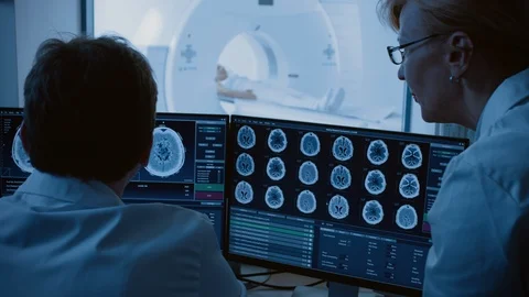 In Control Room Doctor, Radiologist Discuss Diagnosis while Watching Procedure Stock Footage