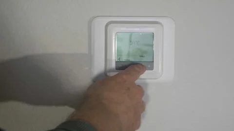 Control of the smart home heating system via a remote climate control with a dis Stock Footage 327441199