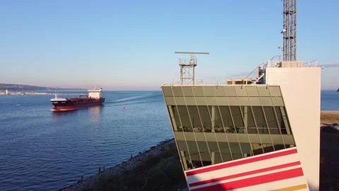 Control tower of ships with big cargo ship entering the port at the evening Stock Footage 214387604