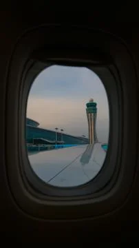 Control tower through the window seat of an airplane at the airport Photos