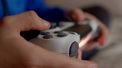 Control a video game hero player grips a controller tightly against a blurred ba Stock Footage 295932199