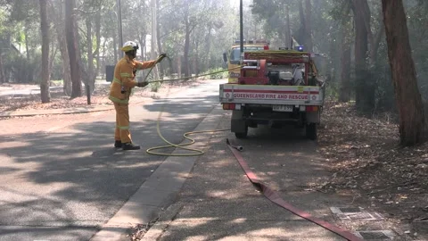Controlled Burn - Firefighter taking hose off truck Stock Footage 162442128
