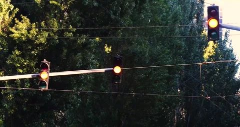Controlled intersection with three traffic lights changing from green to red Stock Footage 346977696