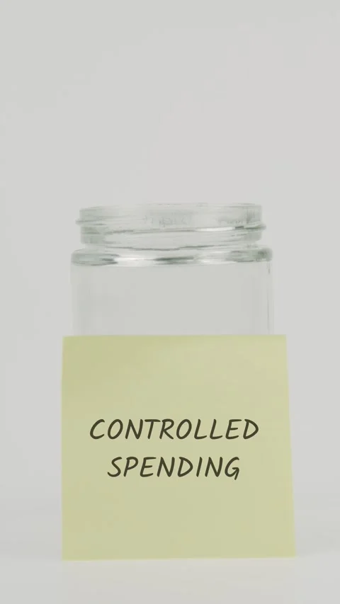 Controlled spending text or word on yellow sticky note attached to glass jar Stock Footage 311699185