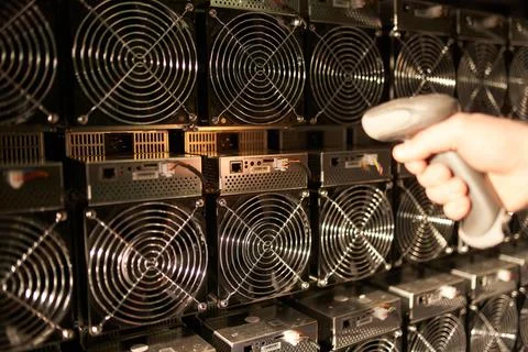 Controller in uniform scans ASIC bitcoin miners with barcode scanner in Stock-Fotos