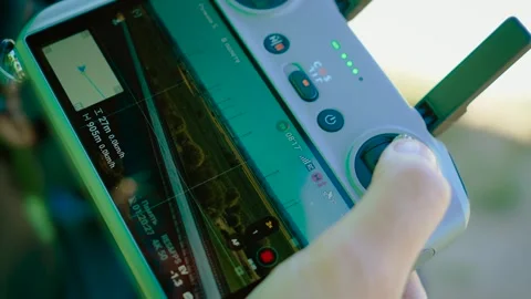 Controlling flying drone with remote screen showing aerial footage close-up Stock Footage 312380373