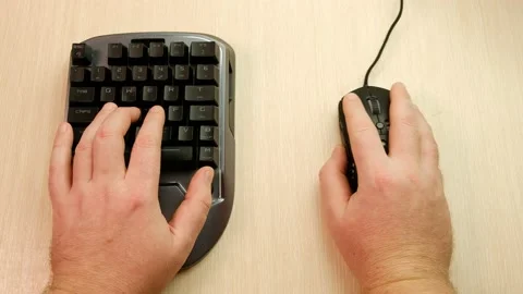 Controlling the game using a modern gaming rgb mouse and a mini keypad. 스톡 동영상 164932526