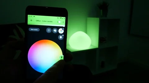 Controlling a Philips Hue smart lamp and changing colors using a cellphone Video stock 104019989