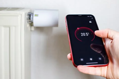 Controlling radiator heating temperature with a smart phone, close-up with ra Stock-Fotos