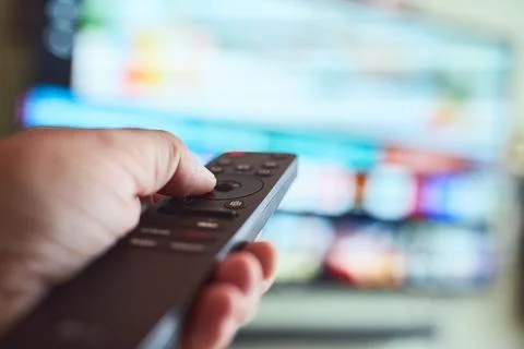 Controlling the television with a remote Stock Photos