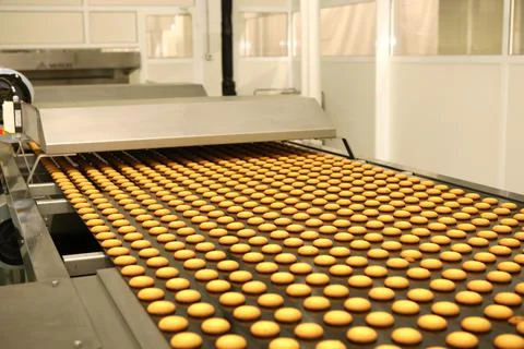 Controlling the work of huge conveyor machine producing spice cakes at the co Stock Photos