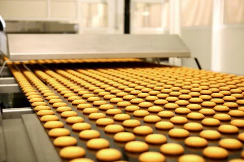 Controlling the work of huge conveyor machine producing spice cakes at the co Foto stock