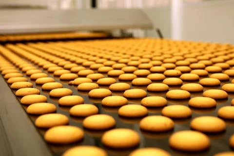 Controlling the work of huge conveyor machine producing spice cakes at the co Stock Photos