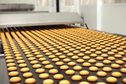 Controlling the work of huge conveyor machine producing spice cakes at the co Stock Photos
