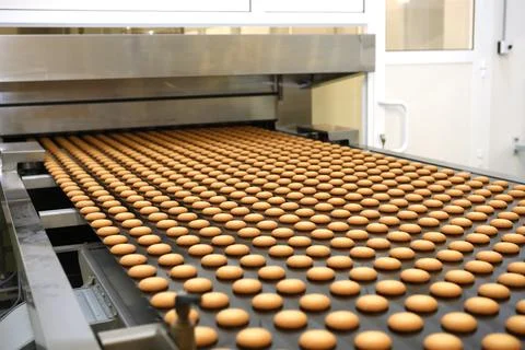Controlling the work of huge conveyor machine producing spice cakes at the co Stock Photos