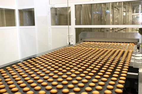 Controlling the work of huge conveyor machine producing spice cakes at the co Stock Photos