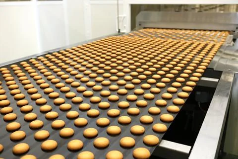 Controlling the work of huge conveyor machine producing spice cakes at the co Stock Photos