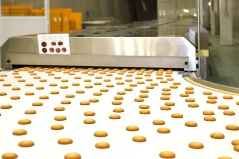 Controlling the work of huge conveyor machine producing spice cakes at the co Stock Photos