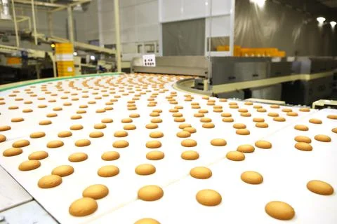 Controlling the work of huge conveyor machine producing spice cakes at the co Stock Photos