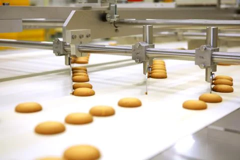 Controlling the work of huge conveyor machine producing spice cakes at the co Foto stock
