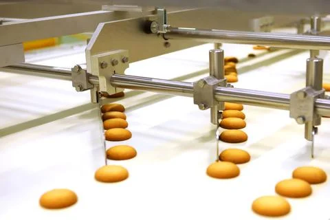 Controlling the work of huge conveyor machine producing spice cakes at the co Stock Photos