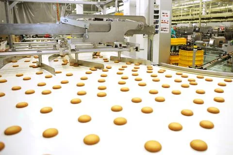 Controlling the work of huge conveyor machine producing spice cakes at the co Stock Photos