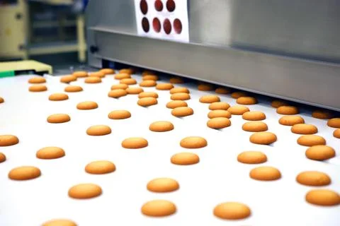 Controlling the work of huge conveyor machine producing spice cakes at the co Stock Photos