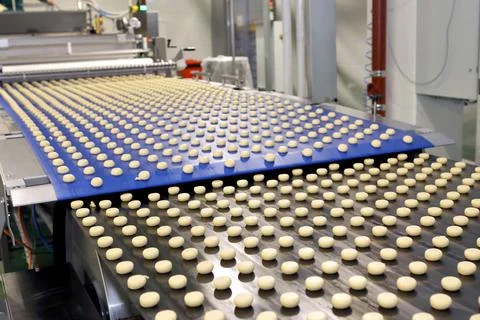 Controlling the work of huge conveyor machine producing spice cakes at the co Stock Photos
