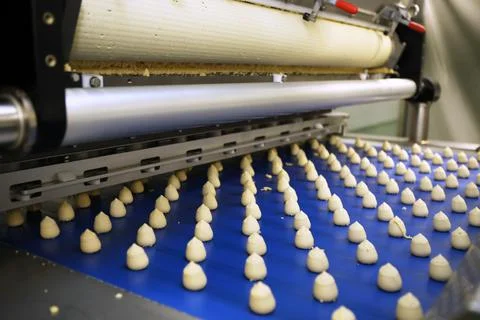 Controlling the work of huge conveyor machine producing spice cakes at the co Stock Photos