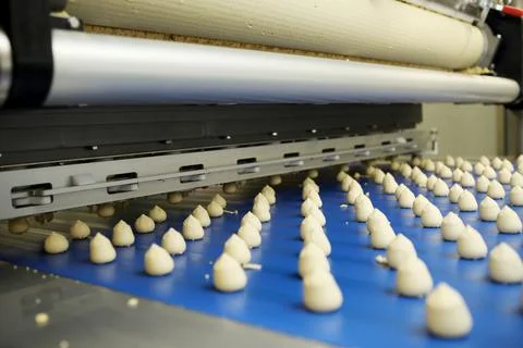 Controlling the work of huge conveyor machine producing spice cakes at the co Stock Photos