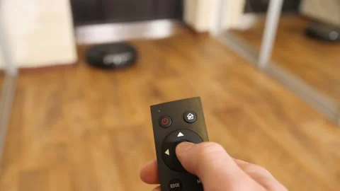 Controls The Robot Vacuum Cleaner Using A Remote Control. Stock Footage 151387081