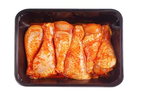 Convenience food,precooked.Marinated chicken dramstick in tray for supermarket Stock Photos