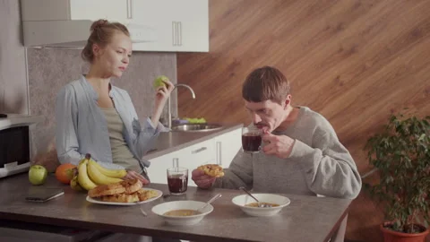 Conversation at home in the kitchen at Breakfast of two young people. A man Stock Footage
