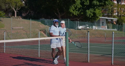 Conversation, interracial and walking with old couple on tennis court for Vídeo Stock 307766248