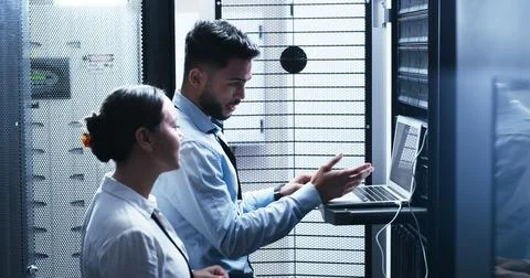 Conversation, laptop and problem solving with people in server room for network Stock Photos