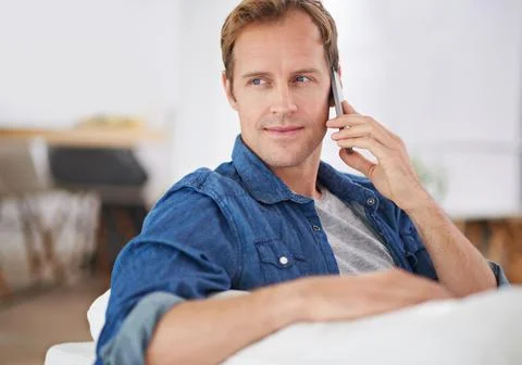 Conversations on the couch. a handsome man talking on the phone while relaxing Stock Photos