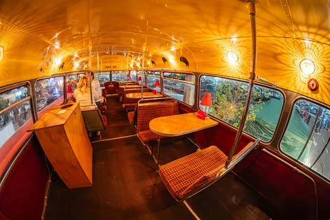 A converted bus interior with seating rows, bar counter, warm lighting, che.. Stock Photos