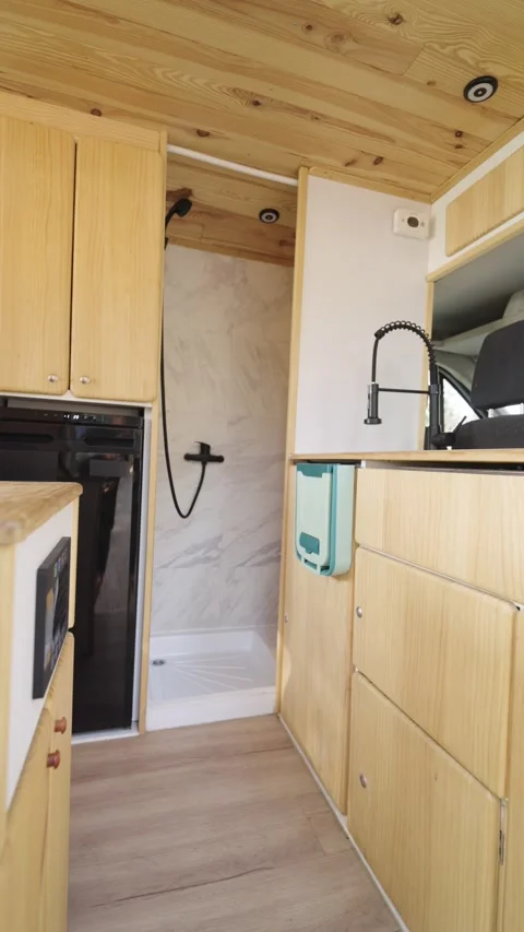 Converted camper van interior featuring wooden furniture. Vertical Stock Footage 344824421