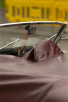 Convertible car interior with folded soft top and chrome windshield frame Stock Photos