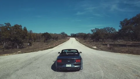 Convertible Car Speeding Off on Road Stock Footage 87607557