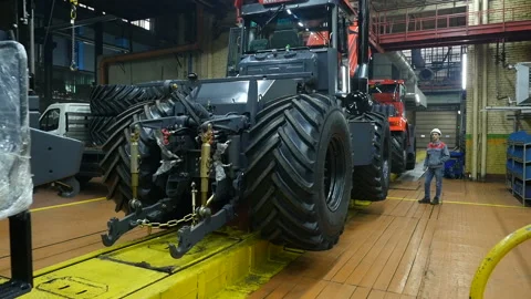 Conveyor assembly of tractor at factory.  Workmen working on a factory. Stock Footage 110017543