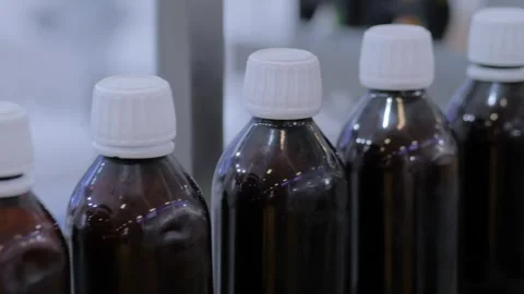 Conveyor belt of bottle labeling machine with empty glass bottles - close up Stock Footage 341321306