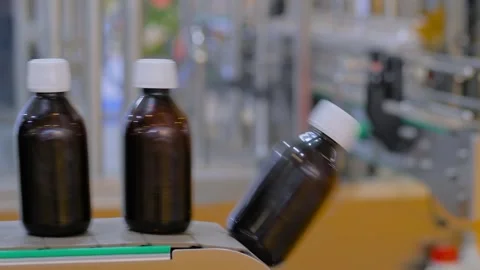 Conveyor belt of bottle labeling machine with empty amber glass bottles Stock Footage 341322787