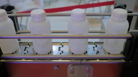 Conveyor belt of bottle labeling machine with empty plastic bottles: close up Stock Footage 341851947
