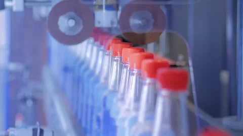 Conveyor belt of bottle labeling machine with empty plastic bottles - close up Stock Footage 344600814
