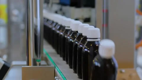 Conveyor belt of bottle labeling machine with empty amber glass bottles Stock Footage 344608760