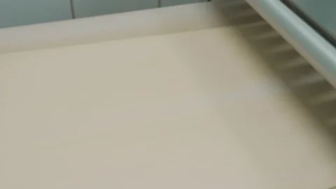 Conveyor Dough is rolled into a ribbon shape and fed to a conveyor belt. Stock Footage 126072204