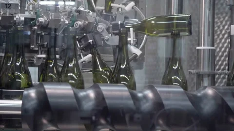 Conveyor with moving bottles on which green wine bottles are washed and turned Stock Footage 230301207